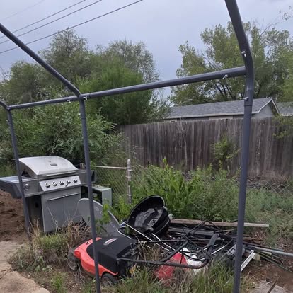 Backyard before: old grill, mower and scrap piled behind the fence